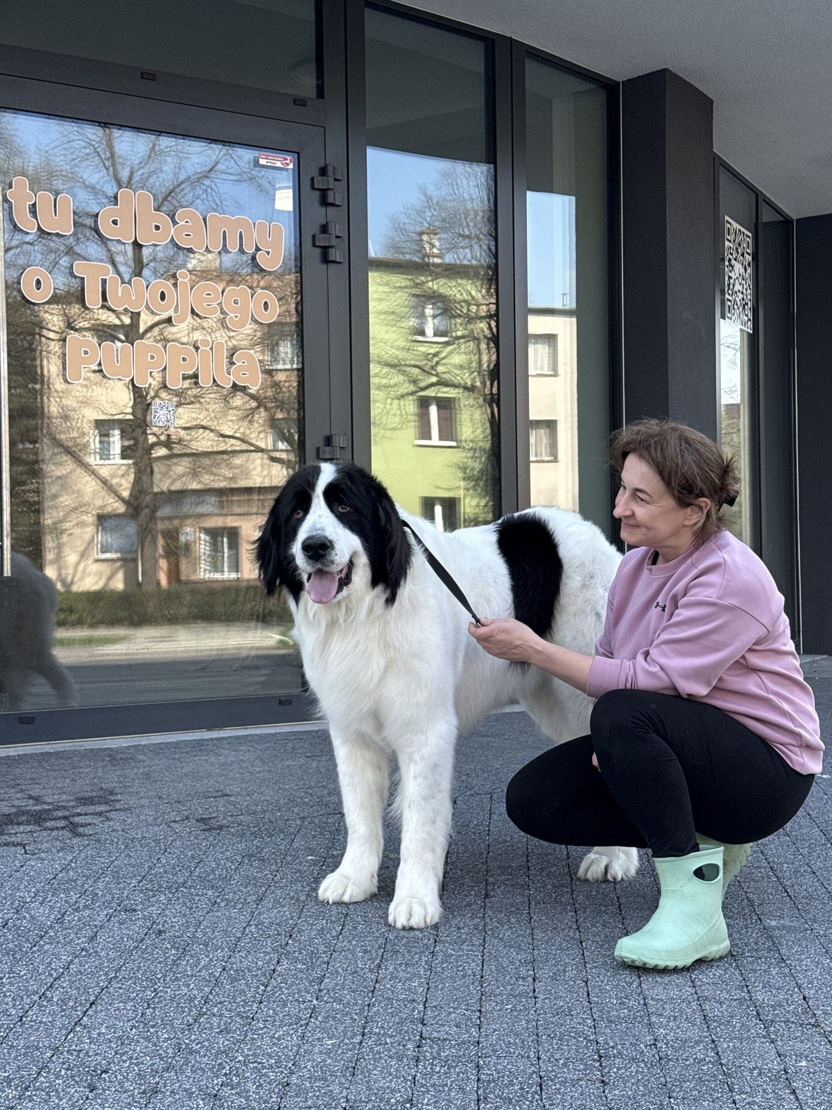 Klientka z dużym psem przy wejściu do salonu Puppuccino w Legnicy